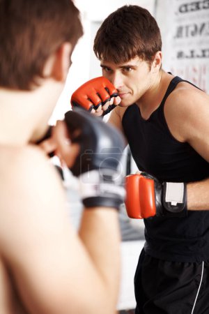 Photo for Man, fighting and boxing in martial arts training with sparring partner for self defense techniques at dojo. Male person, athlete or boxer ready for fight, karate or MMA in jujitsu or match in ring. - Royalty Free Image