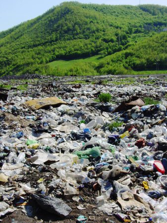 Téléchargez les photos : Pollution, déchets ou déchets avec déchets dans la nature contre une montagne verte comme un danger de changement climatique. Réchauffement climatique, ordures et déchets toxiques pour l'environnement dans un dépotoir ou une décharge illégale. - en image libre de droit