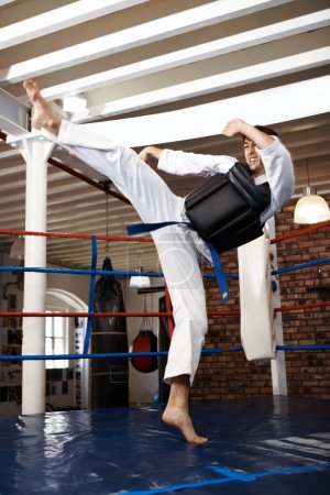 Photo for Man, karate and high kick in training, self defense or jiujitsu for martial arts or fighting match. Male person, athlete or fighter in MMA boxing, muay thai or fitness practice at dojo or gym ring. - Royalty Free Image