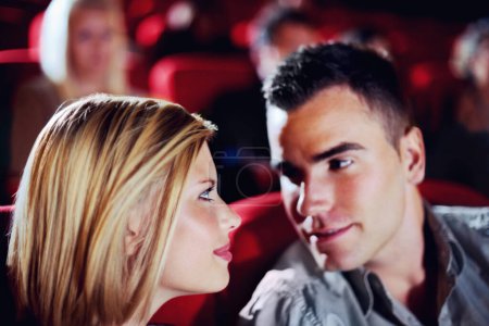 Photo for Cinema, romance and couple watching film, love and romantic date together. Movie night, man and woman in theater with smile, attraction and sitting in auditorium to relax at show with happiness - Royalty Free Image