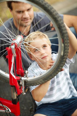 Photo for Bicycle, repair and father help child with bike and learning to fix wheel and parent support kid in vacation or holiday. Smile, development and dad together with son and teaching outdoor skills. - Royalty Free Image