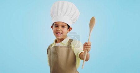Photo for Happy, face and child with a spoon for baking, young chef or getting ready for the kitchen. Smile, boy kid or portrait with equipment for cooking, future career or preparation on a studio background. - Royalty Free Image