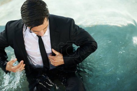 Photo for Water, pool and a business man in debt during depression of the economy or financial crisis. Finance, challenge and unemployment with a young corporate employee wet in a suit during recession. - Royalty Free Image