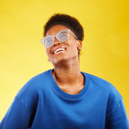 Foto de Feliz, moda y gafas con cara de mujer negra en estudio para visión, cuidado de los ojos y estilo de moda. Gen z, sonrisa y felicidad con la persona femenina sobre fondo amarillo para experto, salud e idea. - Imagen libre de derechos