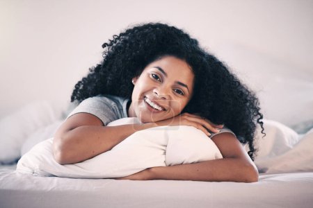 Photo for Happy, smile and portrait of a woman in bed relaxing in the morning on a weekend at her home. Happiness, rest and calm young female person from Colombia lying in the bedroom of her modern apartment - Royalty Free Image