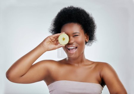 Foto de Mujer negra feliz, retrato y manzana para la dieta, nutrición natural o salud en un fondo de estudio blanco. Rostro de mujer africana sonrisa con fruta orgánica para fibra, vitaminas o cuidado del cuerpo. - Imagen libre de derechos