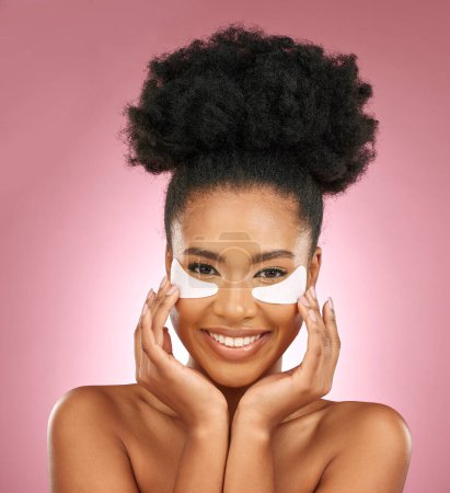 Photo for Skincare, portrait and black woman with patches on eyes, cosmetics and dermatology on pink background. Beauty, collagen and happy model with eye mask for healthy skin glow, smile and care in studio - Royalty Free Image