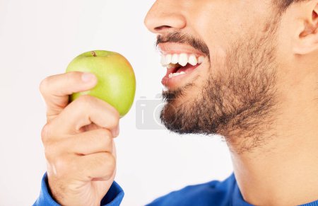 Photo for Closeup, man and hands with apple for diet, natural nutrition or vitamin against a white studio background. Mouth of male person eating healthy organic fruit or bite for wellness, detox or fiber. - Royalty Free Image
