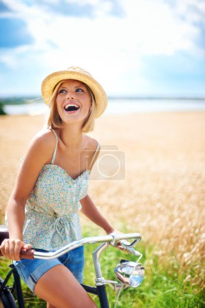 Téléchargez les photos : Femme riant à vélo dans la campagne, le bonheur et Voyage en voyage ou de penser en plein air. Drôle, vélo et personne excitée sourire sur le terrain sur les transports, la liberté et le vélo dans la nature en été. - en image libre de droit