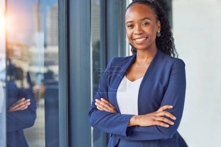 Photo for Portrait, window and arms crossed with a business woman standing in her professional office. Smile, corporate leadership with a happy african manager or boss in the workplace for empowerment. - Royalty Free Image