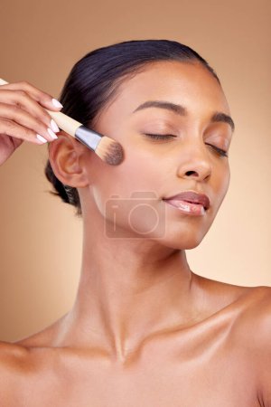 Photo for Beauty, makeup and product with woman and brush in studio for facial, foundation and self care. Cosmetics, spa and tools with face of model on brown background for glow, skincare and dermatology. - Royalty Free Image