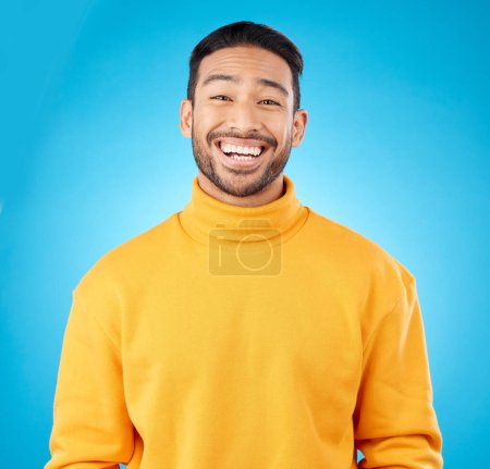 Photo for Laugh, portrait and happy asian man in studio with humor, joke or funny smile reaction on blue background. Comedy, face and Japanese guy model, free emotion or good mood, vibes or positive attitude. - Royalty Free Image