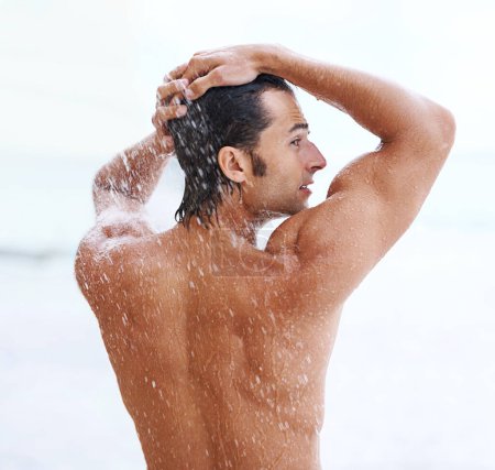 Photo for Shower, beach and man with water for cleaning, washing and grooming for healthy skin. Nature, treatment and back of person with splash for natural hygiene, wellness and skincare hydration outdoors. - Royalty Free Image