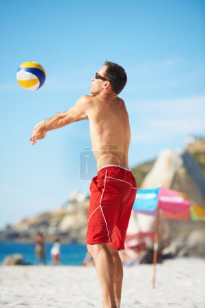 Photo for Beach, volleyball and fitness man at sea with ball serve, energy or freedom on blue sky background. Ocean, sport or guy player with handball in nature for cardio, workout or athletic game performance. - Royalty Free Image