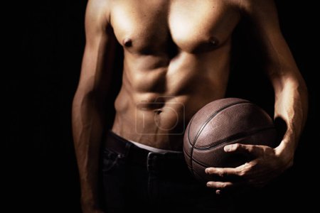Téléchargez les photos : Muscle, corps et mains d'homme avec basket en studio isolé sur fond noir. Sport, gros plan et athlète fort avec ballon, abdos sexy et entraînement pour la forme physique, l'entraînement ou l'exercice pour la santé. - en image libre de droit