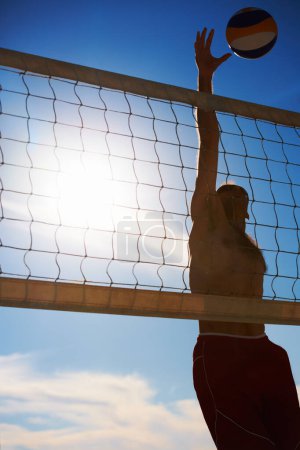 Photo for Volleyball, jump and man at beach with ball serve, energy or freedom on blue sky background. Fitness, sports or male player with handball in nature for cardio, workout or athletic game performance. - Royalty Free Image
