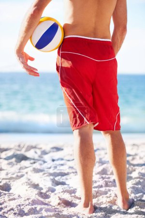 Téléchargez les photos : Plage de sable, océan ou sportif avec ballon de volley pour le jeu en plein air, la compétition ou la recherche de vagues d'eau. Mains, jambes et dos du joueur de volley-ball fitness, entraînement et regarder la nature vue sur la mer. - en image libre de droit
