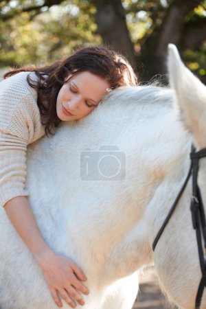 Téléchargez les photos : Nature, amour et femme allongée sur son cheval dans une ferme extérieure pour les courses sportives. Sourire, heureuse et jeune Canadienne avec son animal équestre ou son animal de compagnie dans un ranch rural pour l'aventure - en image libre de droit