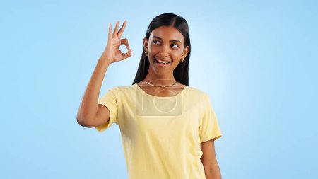 Photo for Woman, OK hand gesture and agreement for success or support with smile and mockup space on blue background. Like, yes and emoji with feedback, vote or opinion in studio with thank you or praise. - Royalty Free Image