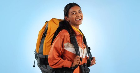 Photo for Hiking studio, backpack and happy woman trekking, backpacking and travel gear for fitness, adventure or tourism holiday. Camping bag, equipment and person smile for trip journey on blue background. - Royalty Free Image