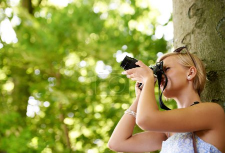 Photo for Woman, photographer and shooting in nature with trees, camera and memory of environment mockup. Spring, park and freelancer filming forest outdoor on summer holiday, trip or travel with technology. - Royalty Free Image