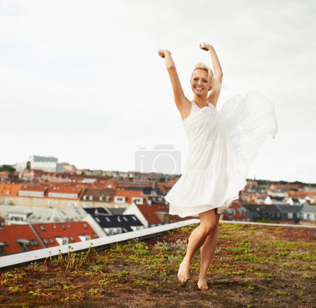 Photo for Woman, happiness and dancing on rooftop, carefree and outdoor with freedom, smiling and city. Wind, dancer and urban area for break, summer and smile on trip, barefoot and amsterdam spring time. - Royalty Free Image