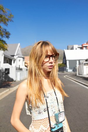 Photo for Travel, photography and young woman with camera for creative and art career by curtain. Tourist, glasses and female person from Australia with dslr equipment for holiday, weekend trip or vacation - Royalty Free Image