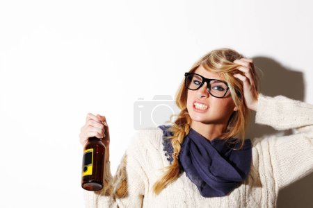 Photo for Portrait, fashion and a bottle of beer with a woman in studio isolated on a white background of space for mockup. Face, alcohol and expression with a young drunk person drinking at a party or event. - Royalty Free Image