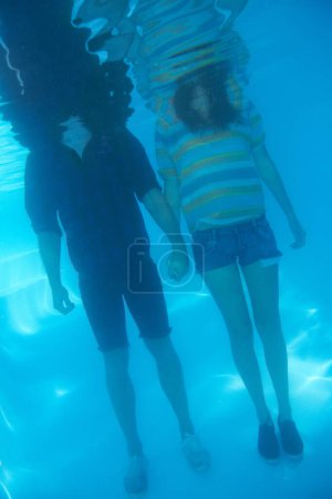 Photo for Holding hands, swimming and a couple underwater for love, support or trust in relationship. Body, standing and a man and woman with care, affection and in a pool together for emotion or unity. - Royalty Free Image