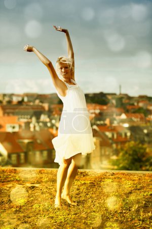 Photo for Dancing, portrait and freedom of woman outdoor on holiday, vacation or travel in city. Happy blonde person with arms raised in celebration, smile and moving with energy in Amsterdam in summer bokeh. - Royalty Free Image