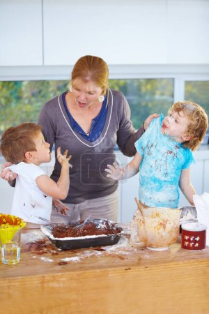 Photo for Family, baking and a mother scolding her children for the mess in a home kitchen with naughty boys. Food, cake or ingredients with a woman yelling at her kids while cooking in an untidy apartment. - Royalty Free Image