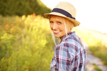 Téléchargez les photos : Sourire, promenade et portrait de femme dans la nature avec un chapeau de paille dans un jardin extérieur pour l'air frais. Heureux, la mode et la femme de l'Australie dans la forêt, les bois ou le champ avec un style décontracté - en image libre de droit