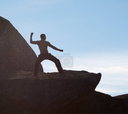 Photo for Karate, fitness man on mountain top for body training, power or defense practice on blue sky background. Martial arts, MMA and male taekwondo master in nature for exercise, sports or morning cardio. - Royalty Free Image