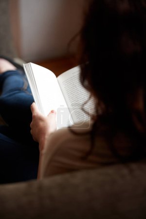 Photo for Reading, books and person relax on sofa, living room and home for research, learning and study. Literature, story and back of woman with book for education, information and knowledge for hobby. - Royalty Free Image