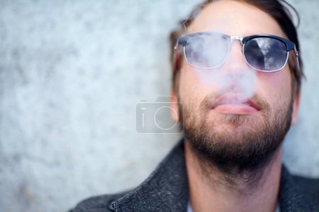 Foto de Cara, hombre y fumar al aire libre con gafas de sol para la adicción, la experiencia y el disfrute en el espacio de la maqueta. Persona, hipster y humo en maqueta para estilo de vida, lujo y exhalación o satisfacción con el tabaco. - Imagen libre de derechos