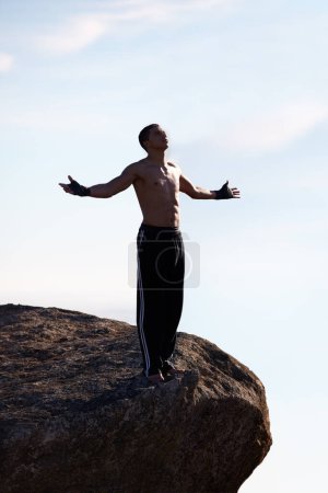 Photo for Mountain top, freedom and fitness man with open arms in nature for training, wellness or sports on sky background. Exercise, success and athlete with morning cardio, gratitude or workout celebration. - Royalty Free Image