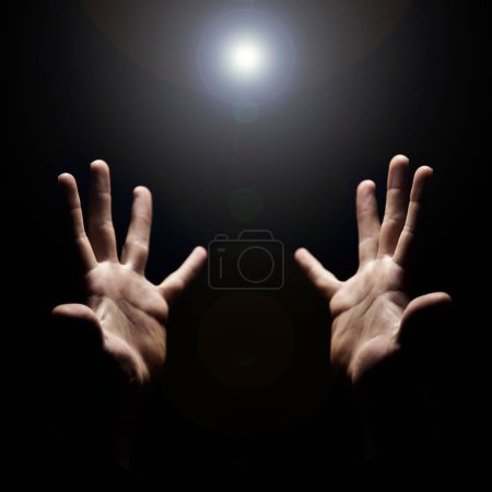 Photo for Hands, pray and help from God with praise, closeup of holy person with gratitude and respect for religion. Guide, wellness and lens flare, worship and faith with hope and trust on dark background. - Royalty Free Image
