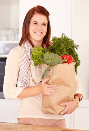 Photo for Woman, kitchen and vegetables from grocery shopping, smile and food with nutrition, organic and cooking. Healthy, home and vegan for diet, happy and wellness for fresh salad, vegetarian and produce. - Royalty Free Image