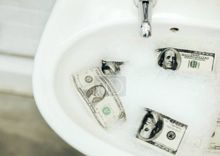 Photo for Bubble water, cash and money in a basin for deal, inflation or budget in a bathroom at home. Wealth, soap and dollar bills in foam in a sink for economic fraud or bankruptcy at modern house - Royalty Free Image