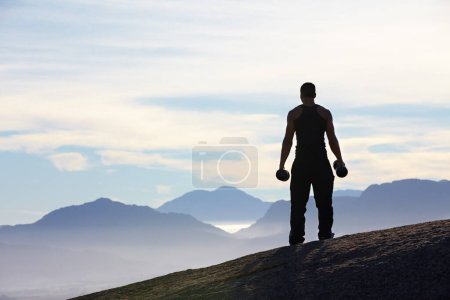 Téléchargez les photos : Fitness, haltérophilie et dos de l'homme avec haltères sur le sommet de la montagne pour le cardio du matin sur fond de ciel. Poids, liberté et vue arrière du bodybuilder masculin dans la nature pour l'entraînement, la puissance ou l'entraînement. - en image libre de droit