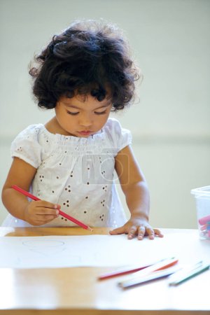 Photo for Young girl, drawing and classroom for creative development, education growth in kindergarten. Child, daycare and table pencils artwork for learning play in school or paper crayons, kid craft or color. - Royalty Free Image