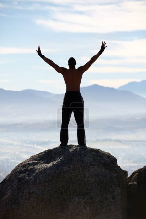 Photo for Mountain top, success and back of fitness man stretching arms in nature for performance celebration on sky background. Exercise, freedom and rear view of male athlete with workout, energy or victory. - Royalty Free Image