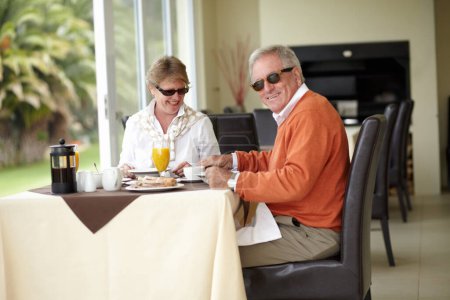 Foto de Desayuno, retrato y pareja de personas mayores en el restaurante en una cita romántica juntos en la mañana de verano. Hombre viejo, mujer feliz y sonrisa en la hospitalidad de lujo, buena comida y relajarse en la cafetería con gafas de sol. - Imagen libre de derechos