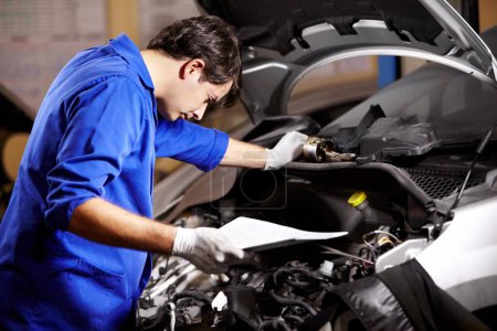Photo for Document, man and technician check engine of car, repair and maintenance. Checklist, mechanic and serious person on motor vehicle hood, inspection list or fixing transportation at auto service garage. - Royalty Free Image