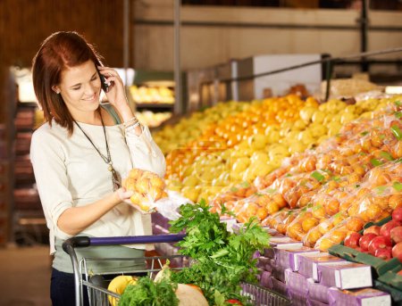 Foto de Mujer, habla y smartphone con compra de verduras para comida sana, supermercado y comunicación. Feliz, persona y llamar al teléfono celular en la tienda de comestibles, frutas y tiendas de bienestar para la nutrición. - Imagen libre de derechos