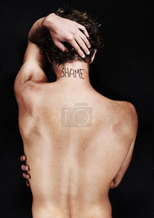 Photo for Back, shame tattoo and nude man in studio isolated on a black background. Rear view, regret and body of person embarrassed at mistake, fail and abuse crisis, depression and mental health challenge. - Royalty Free Image