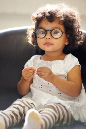 Photo for Girl, child and portrait or glasses for play, learning development or education growth. Female person, toddler and face eyewear on sofa in home for comedy outfit as professional, intelligence or fun. - Royalty Free Image