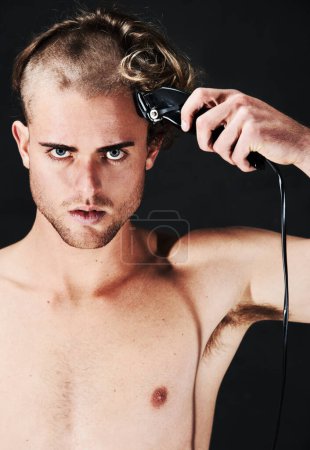 Photo for Portrait, body and serious man shaving hair or head in studio isolated on a black background. Face, haircut machine and naked person at hairdresser salon with trimmer for wellness, care and hairstyle. - Royalty Free Image