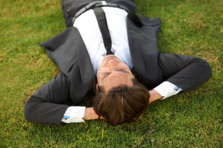 Photo for Relax, grass and a business man lying on a field outdoor from above for the success of a completed task. Sleep, dreaming or rest with a corporate employee chilling at a garden or park in summer. - Royalty Free Image