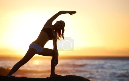 Téléchargez les photos : Silhouette, yoga ou pilates pour l'équilibre sur la plage avec pose pour étirement, santé ou bien-être. Femme, instructeur et ombre au coucher du soleil pour un mouvement relaxant, la méditation ou spirituelle pour la paix avec zen. - en image libre de droit
